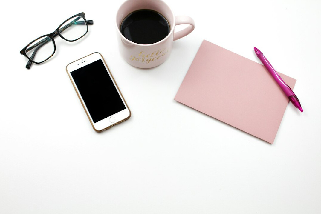 Overhead flat lay of a workspace with laptop coffee and notebook